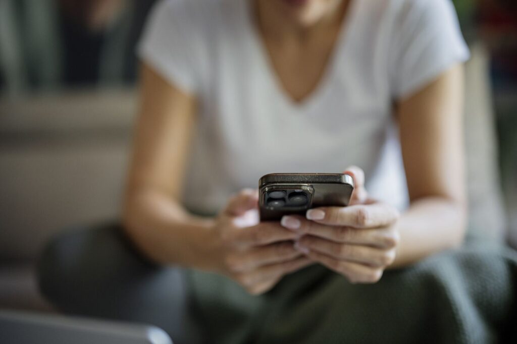 A person smiling while looking at a smartphone